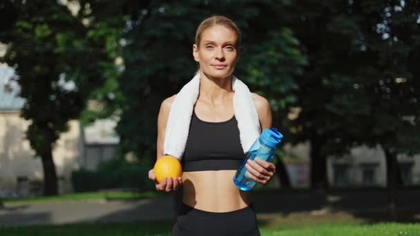 Porträtt Kaukasiska Idrottskvinna Som Håller Flaskan Med Vatten Färsk Orange — Stockvideo