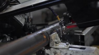 Endüstriyel makine aşırı ısınmayı kontrol etmek için su altındaki boruları kesiyor. Modern teknolojinin kullanımıyla üretilen metal işleme yerini kapatın. Ekipman ve inşaat kavramı.