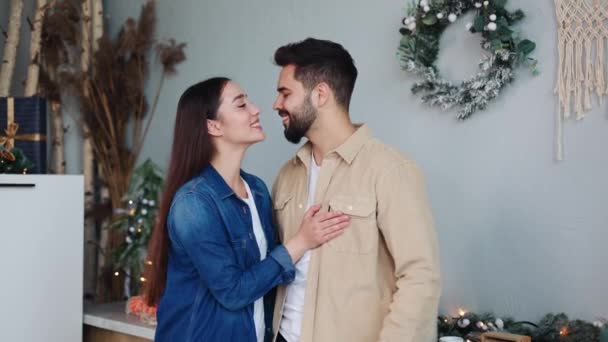梦幻般的年轻夫妇站在厨房里拥抱 在圣诞佳节的时候想着美好的未来 快乐的丈夫拥抱着妻子 梦想着在新房子里摆姿势拍照 — 图库视频影像