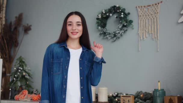 ホワイトティーの愛らしい笑顔の少女は バックドロップで照らされたクリスマスツリーで休日をテーマにしたキッチンのワークスペースを強調しています 休日の広告やプロモーションの新年コンテンツのプライム設定 — ストック動画