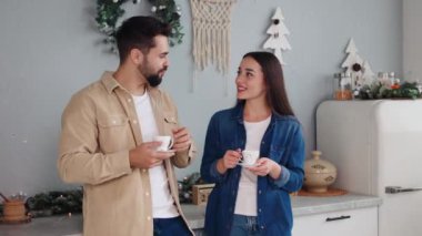 Erkek ve kadın, Noel için süslenmiş olarak mutfakta duruyor, mis kokulu kahveyi yudumluyor ve gelecek yılın planlarını tartışıyorlar. Noel ve yeni yılı gelecek için iyimser planlarla kutluyoruz..
