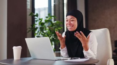 Siyah başörtüsü takmış neşeli, çok ırklı ofis çalışanı iş yerinde neşe saçıyor. Kablosuz bilgisayarda inanılmaz haberler okurken, heyecanlı bir şekilde gülümseyen ve yumruğunu sıkan bir kadın..