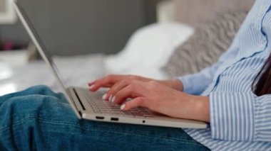 Otelde dizüstü bilgisayarda çalışan, yatakta oturan, iş gezisi sırasında ışıl ışıl gülümseyen güzel başarılı iş kadını. Mesafe çalışması, iş.