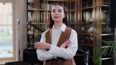 Kendine güvenen, şık, güçlü iş kadını, girişimci, kadın lider, Kafkasyalı kadın kafe çalışanı, restoran ofisinde el ele tutuşan feminizm kameralarına bakıyor. Yüz resmi.