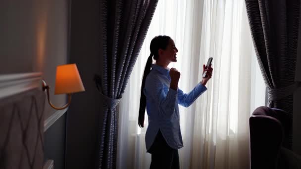 Lucky Businesswoman Stoi Pobliżu Okna Pokoju Hotelowym Świętując Sukces Niesamowite — Wideo stockowe