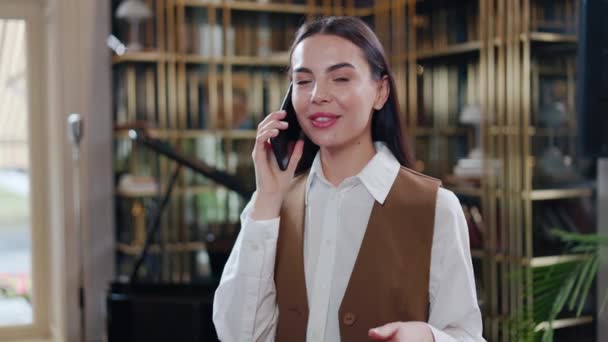 Usmívající Podnikatelka Dlouhými Vlasy Konverzuje Mobilním Telefonu Hotelovém Salonku Radostná — Stock video