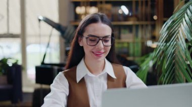 Beyaz bluzlu ve gözlüklü neşeli kadın bir kafede oturup, kablosuz bilgisayarı üzerinde çalışıyor. Kafkas iş kadını dostça bir gülümsemeyle kameraya bakıyor. Kız bir kafe sahibi..