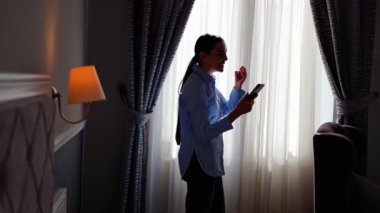 Siluet güzel milenyum kadını cep telefonu ekranına bakıyor, inanılmaz iyi haberlerle mesaj okuyor, online piyango kumarını kutluyor, gizli satış bildirimi alıyor..