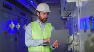 Mavi Fütüristik Sanayi Üretim Tesisi 'nde dizüstü bilgisayar üzerinde çalışan Kafkas Fabrikası Uzmanı. Proje Yöneticisi İş Verilerini Bilgisayarda İzliyor, Kameraya Gülümseyerek Bakan Raporları Denetliyor.