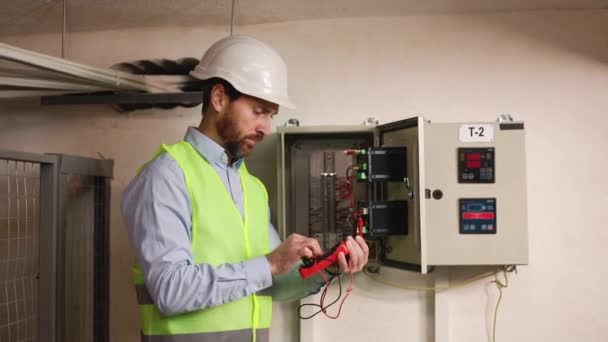 Serious Electrician Electrical Tester Inspecting Switchboard Functionality Power Substation Technician — Stock Video