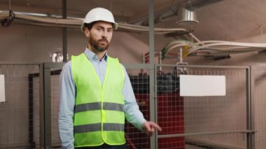 Neşeli, uzman elektrikçi jestleri elektrik ağındaki reklamlar için boş tabelalara yöneliyor. Erkek mühendis el hareketi yapıyor, kopyalama alanı ya da şablon düzeni..
