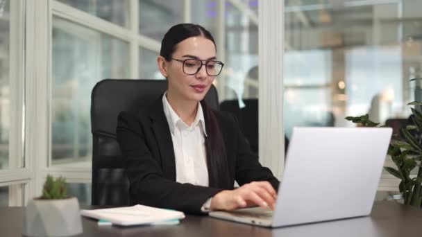 积极的女企业家坐在笔记本电脑键盘上打字 梦想着成功的事业 白种人黑发在办公室的职业阶梯上表现出自信和良好的期望 — 图库视频影像