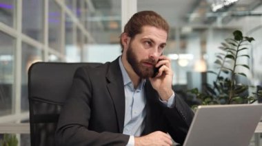 Başarılı bir erkek programcı, kişisel ofis kabinesinde modern akıllı telefonla konuşurken interinterinterlocutor ile aynı fikirde. Yakışıklı beyaz iş adamı iş akışı sırasında içeride sohbet ediyor..