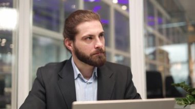 Beyaz, sakallı, resmi kıyafet giyen, kablosuz bilgisayarın yardımıyla internette gezinen yakışıklı bir adam. Rahat bir ofiste masa başında çalışırken parlak fikirleri değerlendiren şık bir uzman..