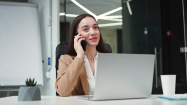 Başarılı bir bayan yönetici, kişisel ofis dolabında modern akıllı telefondan konuşurken araya giren kişiye tepki veriyor. Çekici beyaz iş kadını iş akışı sırasında içeride sohbet ediyor..