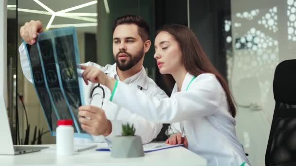 Visão Frontal Dois Médicos Caucasianos Discutindo Resultados Raio Fazendo Anotações — Vídeo de Stock