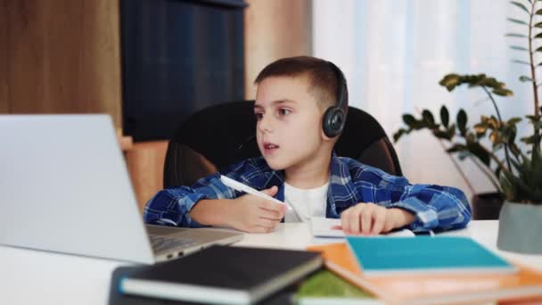 Attentive Child Using Headset Microphone Learning Home Interior Surrounded Workbooks — Stock Video
