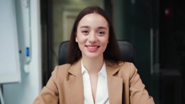 Modern dizüstü bilgisayar kamerasından duygusal bayan girişimcinin ofis içi iş ekibiyle online görüşmesi. Yetenekli beyaz kadın gülümseyerek yeni bir projeden bahsediyor..