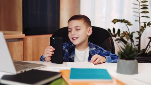Przyjazny Dzieciak Mający Rozmowę Wideo Nowoczesnym Smartfonie Pomiędzy Zajęciami Online — Wideo stockowe