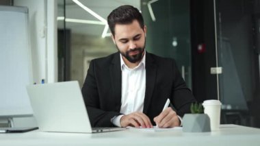 Kafkas iş adamı modern dizüstü bilgisayarın yanında şirket gelirini arttırmak için sözleşme imzalıyor. Başarılı patron, tasarımcı kabinesinin arka planındaki kişisel aygıt bilgilerini denetliyor.