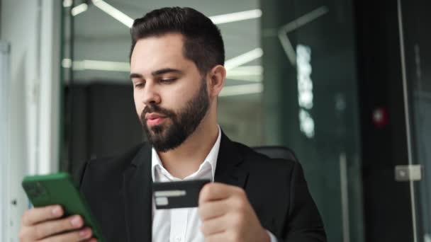 Verwirrter Mann Gibt Bankkartendaten Persönliches Smartphone Ein Während Schreibtisch Vor — Stockvideo