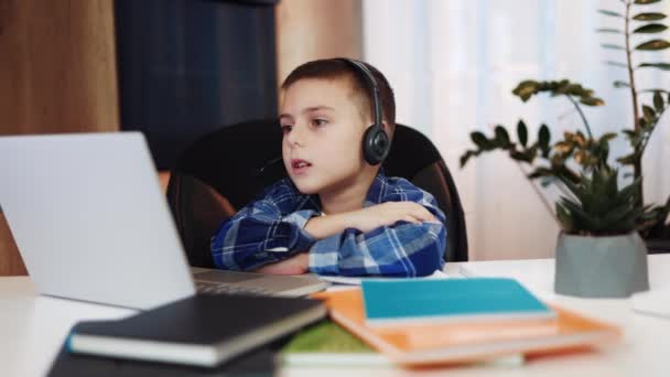 细心的高加索男孩 带着耳机 在无线笔记本电脑上与老师进行视频通话 聪明的男孩在课余时间参加课外活动 教育和技术的概念 — 图库视频影像