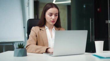Kadın şirket çalışanı mutsuz ve kızgın görünürken reddedilme ve olumsuzluğu baş parmaklarıyla gösteriyor. Genç üzgün Kafkas kadın şirket ofisinde kişisel dizüstü bilgisayarla çalışıyor..