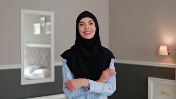伝統的なヘッドスカーフを身に着けているカメラにフレンドリーに見える独立したムスリムのビジネスマンの閉じた肖像画 ホテルの部屋でヒジャーブで女性アラビア人の肖像画 中東の美顔の肖像 — ストック動画
