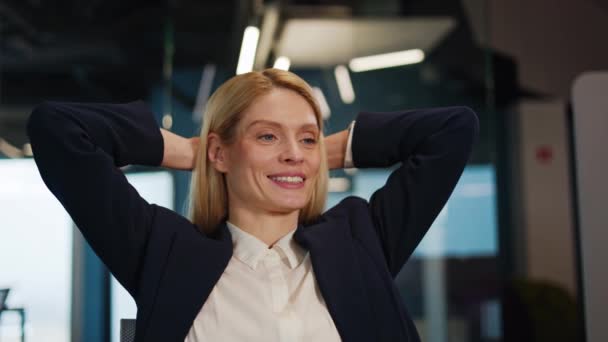 満足した慎重なビジネス女性は オフィスデスクでリラックスして ラップトップコンピュータの仕事は仕事でよく行われたストレス解消の心のコンセプトチルで満足して頭の後ろに手を置きます — ストック動画