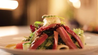 Salata karışımı, domates, salatalık, tatlı kağıt ve lüks restoranın bulanık arkaplanlı ızgara ton balığı. Aşçıdan sofistike bir yemek servisi..