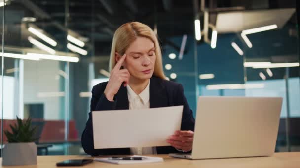 Ciddi Genç Kadını Ofis Masasında Oturmuş Şirket Evraklarını Kontrol Ediyor — Stok video