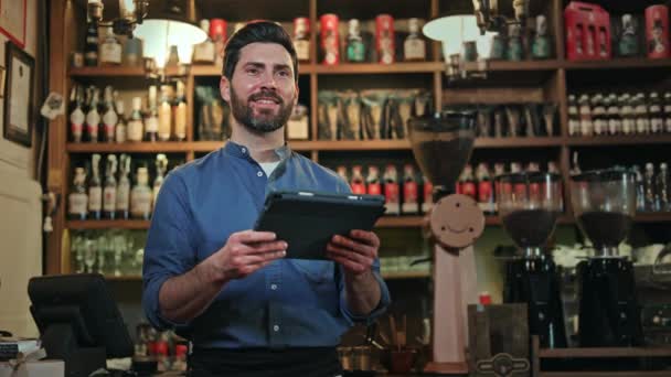 成功的创业者在酒吧柜台旁使用数字平板电脑查看商务邮件 穿着蓝色衬衫的男工在现代设备上打字 并更新自助餐厅的在线菜单 — 图库视频影像