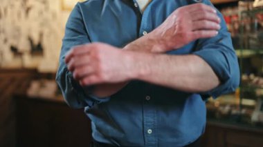 Lüks bir restoranın içinde kollarını kavuşturmuş başarılı yemek servisi çalışanlarına yakın durun. Becerikli garsonlar mavi gömlekli, kolları kıvrılmış ve siyah önlüklü..