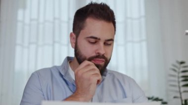 Odaklanmış esmer adam belgelerdeki verileri dikkatlice analiz ediyor ve kişisel iş yerindeki bilgisayara giriyor. Finans bölümü öğrenim personeli raporu başkanı ve düzeltmeleri e-postayla gönderiyor.