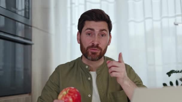 Yakışıklı Erkek Blogcu Sulu Kırmızı Elmayı Isırıyor Evde Kablosuz Bilgisayarla — Stok video