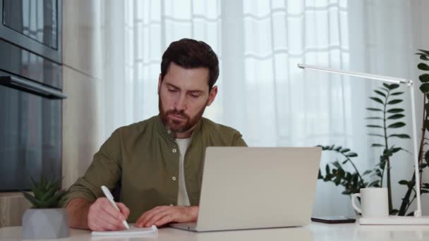 Konzentrierter Mann Der Schreibtisch Sitzt Während Sein Notizbuch Benutzt Und — Stockvideo