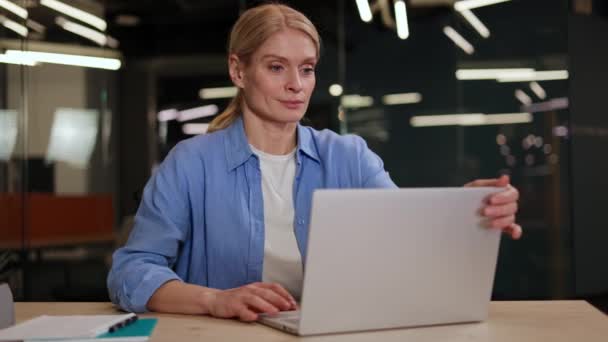 笑顔の独立請負業者女性は 職場に座っている間 コンピュータワークを伸ばしてリラックスさせました プロジェクトの達成と時間内に完了した美しい白人女性 — ストック動画