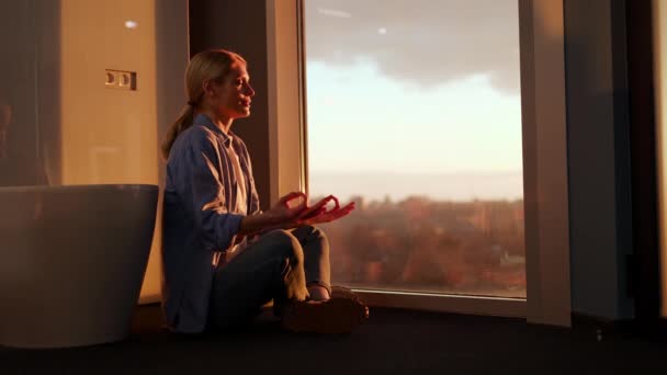 Zufriedene Frau Meditiert Und Schaut Aus Dem Großen Fenster Während — Stockvideo
