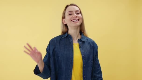 노란색 스튜디오 배경에 오른손으로 제스처를 만드는 머리를 여자의 실내에서 계약을 — 비디오