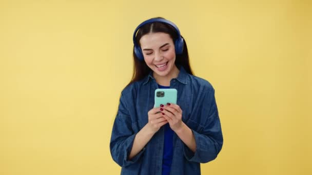 Elinde Modern Akıllı Telefon Kafasında Kablosuz Kulaklıkla Sevdiği Şarkıda Neşeyle — Stok video