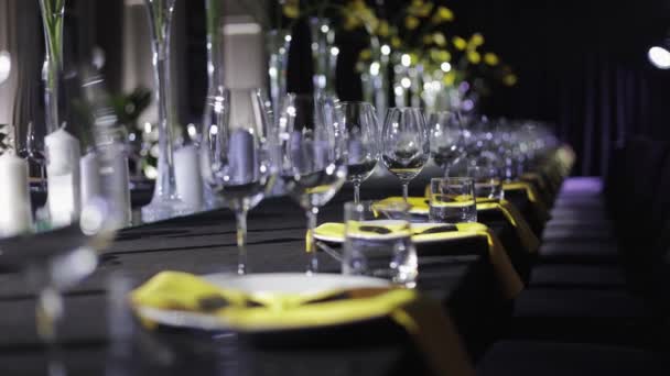 노란색 냅킨의 형태로 반짝이는 와인글라스 도자기 접시와 사항으로 테이블을 제공합니다 — 비디오