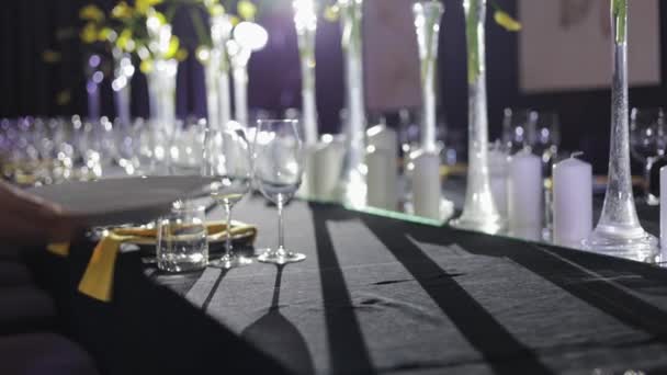 无名氏活动策划者为众多客户完成餐桌布置 并连续布置餐具 用水晶花瓶和未点燃的蜡烛装饰就餐区的最后步骤 — 图库视频影像