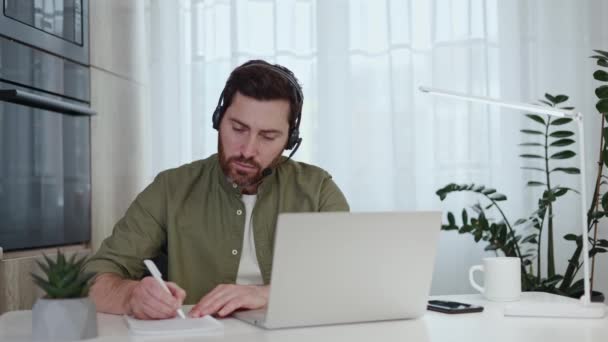 Cara Concentrado Notas Escrita Camisa Verde Usar Laptop Moderno Fones — Vídeo de Stock