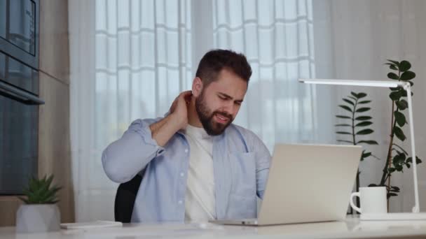 リモート起業家は ノートパソコンと筋肉を伸ばしながら机に座っている間 慢性脊髄痛に苦しんでいます 痛みの軽減のための正しい座席姿勢に入ろうとするハードワークフリーランサー — ストック動画