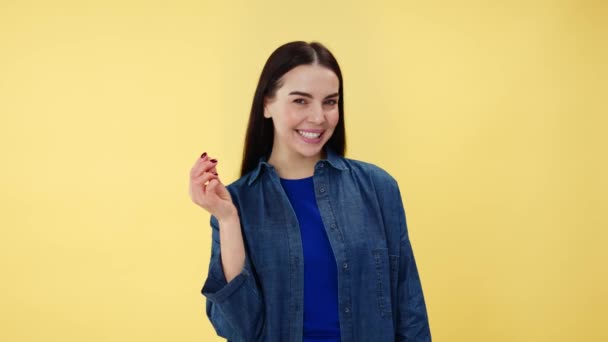 Portret Uśmiechniętej Młodej Kobiety Dżinsowej Koszuli Wykonującej Gest Pieniężny Palcami — Wideo stockowe