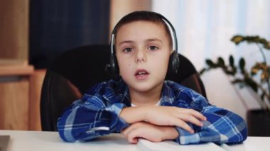 Kablosuz kulaklıklı yakışıklı adamın evde uzaktan öğrenme sırasında tepki verdiği ilk kişi. Çekici erkek çocuk evde otururken ev ödevi hakkında heyecanla konuşuyor..