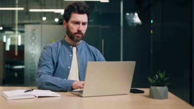 Not defterinin yanında bilgisayar başında çalışan stresli ofis yöneticisi ve kafası teçhizatlı kabineyi teslim ederken gergin boynunu esnetiyor. Aşırı yorgun profesyonel masaj ile omurilik kramplarını gidermeye çalışıyor..