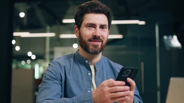 Retrato Homem Confiante Mudando Olhar Tela Smartphone Para Câmera Sorrindo — Vídeo de Stock