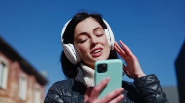 Müzik aşığının portresi, telsiz kulaklığa dokunuyor. Telefona elle bağlanıyor ve zevkle gözlerini kapıyor. Kaygısız kadın şarkı söylemeye başlar ve gülümseyerek şarkı söyler..