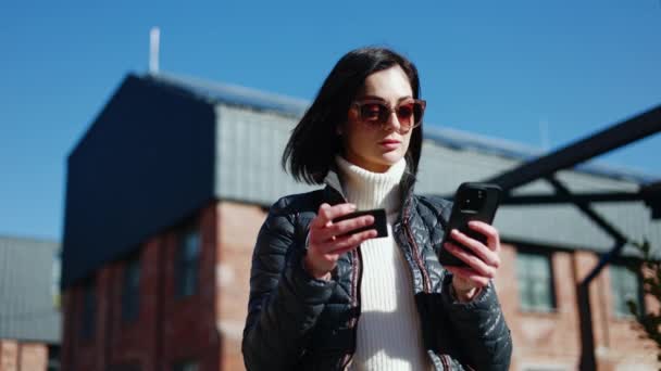Sfrustrowana Kobieta Stylowych Okularach Pomocą Mobilnego Gadżetu Kartą Kredytową Ręku — Wideo stockowe
